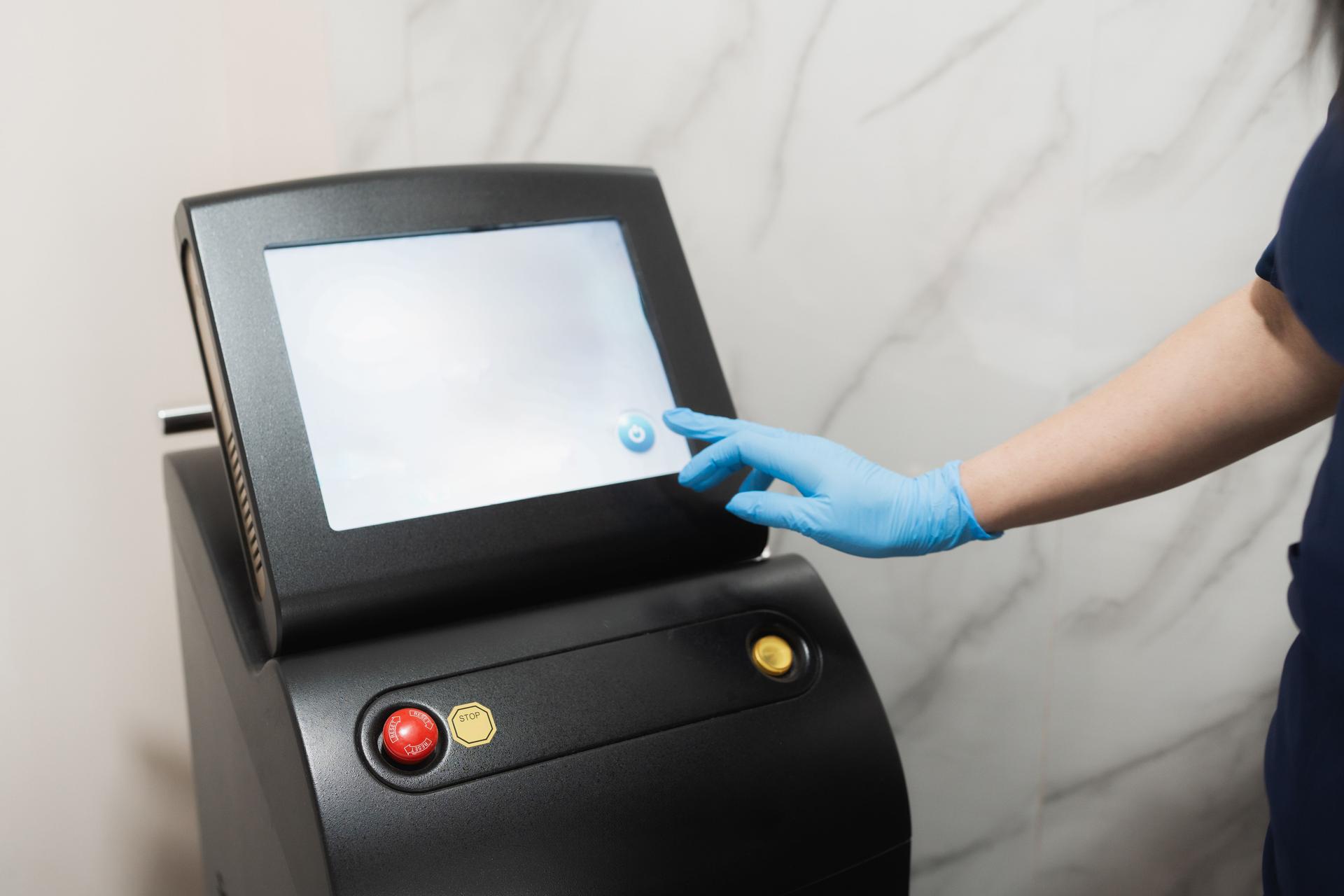 Beautician wearing gloves using professional laser hair removal machine